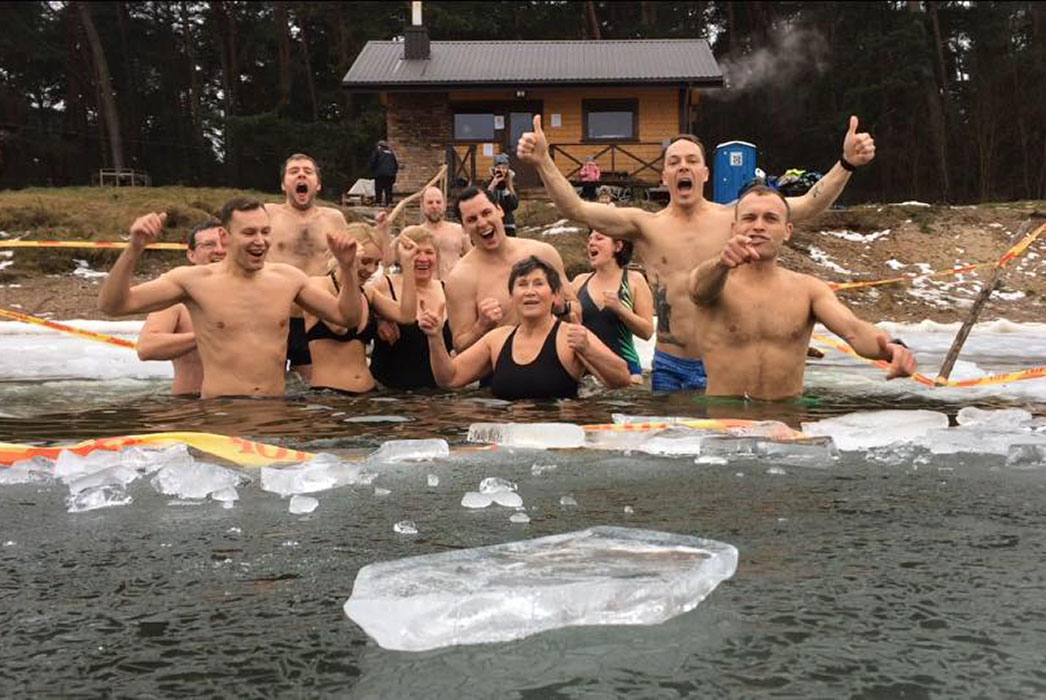 Eleven men and women standing waist high in water, laughing, shouting, surrounded by floating ice!